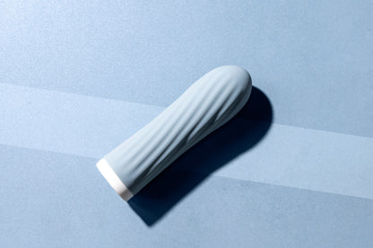 Blue bullet vibrator laying down on matching blue background
