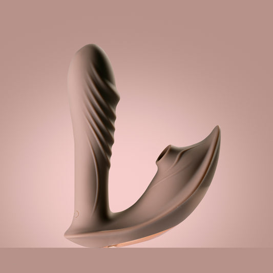 Coffee clitoral suction vibrator with swinging head standing upright, dark pink background

