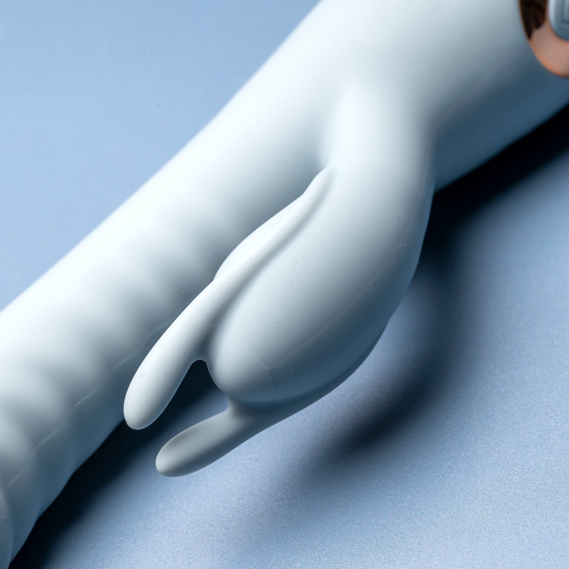 Close-up of blue rabbit vibrator’s soft ears, blue background

