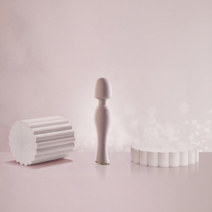 Pink wand vibrator standing on reflective pink surface with bokeh light background