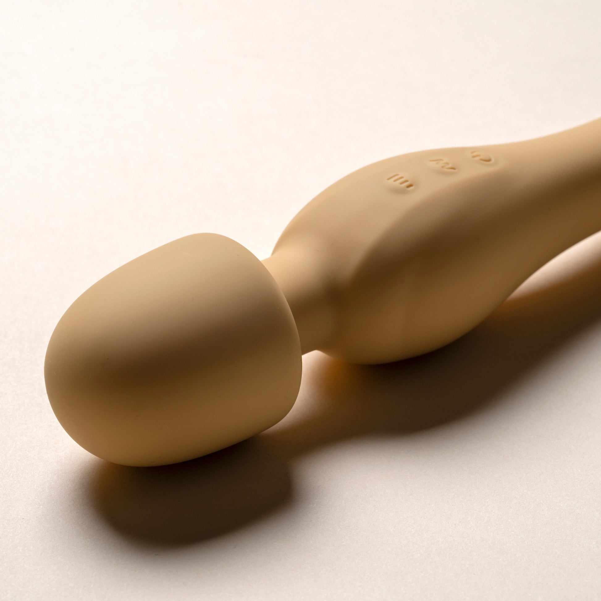 Yellow wand vibrator massager on a light beige background